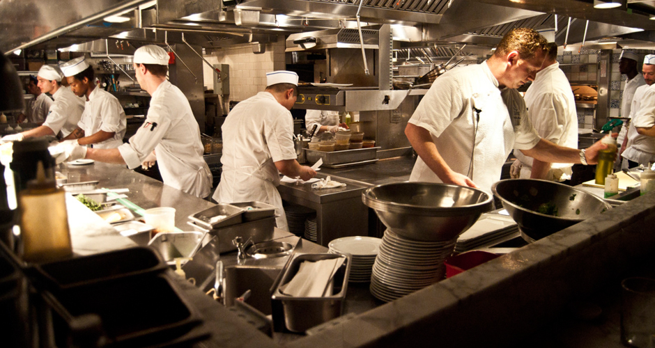 Busy commercial kitchen staff working in a restaurant and following best grease management practices